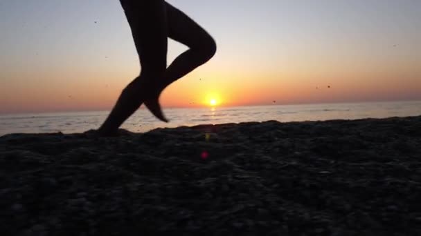 Una giovane donna che corre lungo la spiaggia sabbiosa del mare . — Video Stock