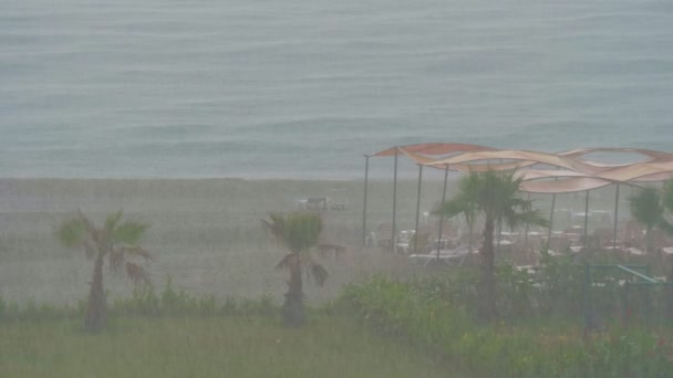 Ciężki deszcz na pustej plaży kurortu. — Wideo stockowe