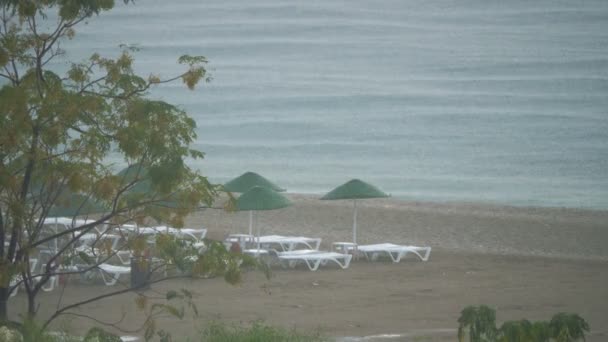 Lluvia fuerte en la playa vacía del resort . — Vídeo de stock