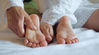 Anne bebek ayaklarına masaj yapıyor..