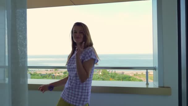 Flicka dans lambada på balkongen på hotellet med utsikt över havet eller havet. — Stockvideo