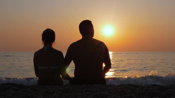 Ένας άντρας με μια γυναίκα να βλέπει ένα πολύχρωμο ηλιοβασίλεμα.. — Αρχείο Βίντεο