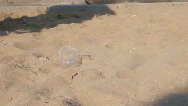 Fille ramasser des déchets en plastique à l'aire de jeux pour enfants ou plage de sable .