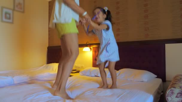 Мама и дочь прыгают на кровати в гостиничном номере . — стоковое видео