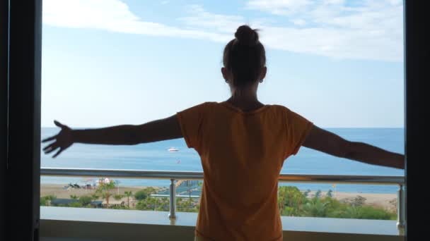 Jonge vrouw voegt handen met palmen samen in namaste op het balkon van het hotel. — Stockvideo