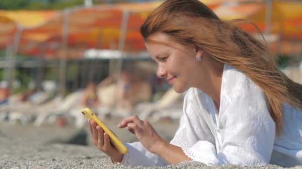 Frau benutzt Smartphone am Strand — Stockvideo