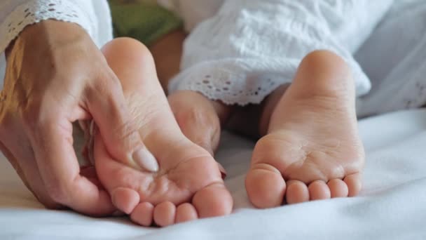 Matka masáže její babys nohy zblízka. — Stock video