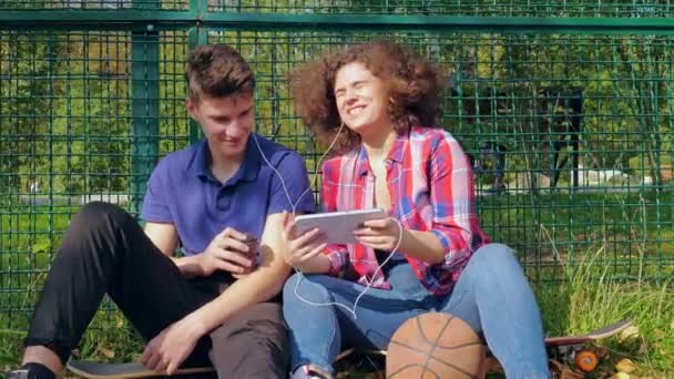Зміст молода жінка дивиться планшет з другом на вулиці — стокове відео