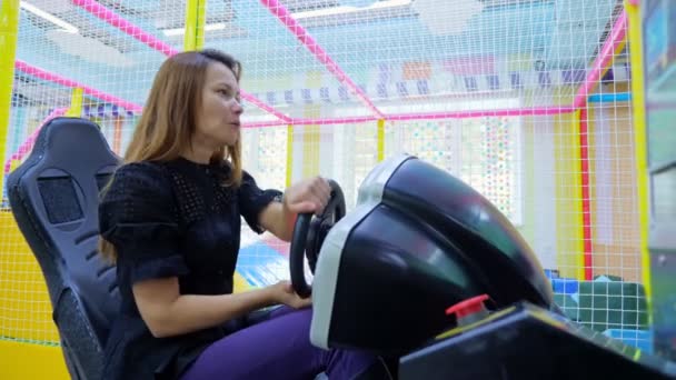 Jovem mulher se divertindo enquanto monta no simulador de carro — Vídeo de Stock