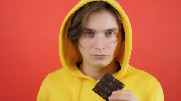 Genç adam tatlı çikolata yiyor.