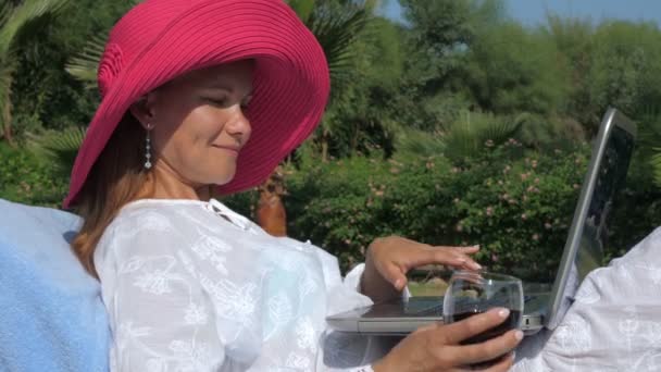 Contenida freelancer femenina usando laptop con copa de vino de vacaciones — Vídeos de Stock