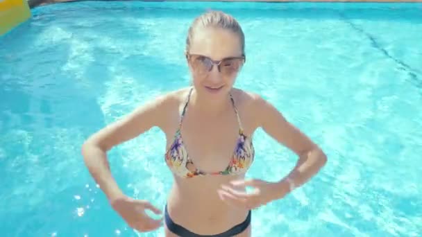 Jonge vrouw vallen op haar rug in het zwembad. — Stockvideo