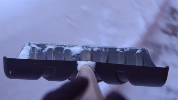 Person mit Schaufel räumt Schnee vom Hof — Stockvideo