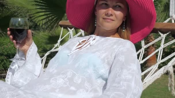 Mujer relajada con copa de vino en un resort exótico — Vídeo de stock