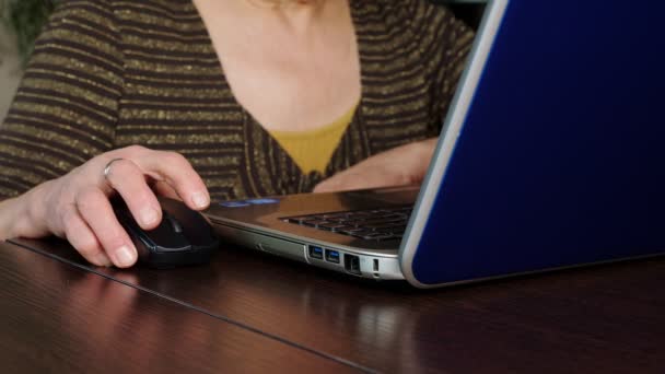 Uma mulher idosa usa um laptop em casa . — Vídeo de Stock