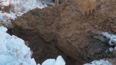 Loader digging wet ground in winter