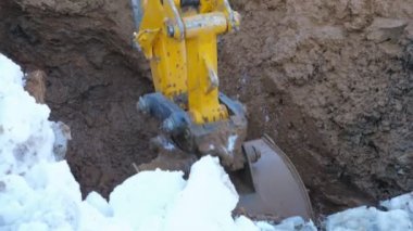 Loader digging wet ground in winter
