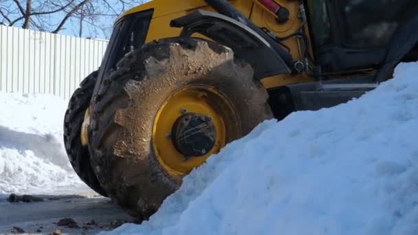Современный трактор с грязными колесами возле снега — стоковое видео