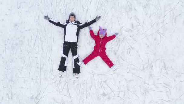 Γυναίκα και παιδί ξαπλωμένοι στον πάγο στο παγοδρόμιο — Αρχείο Βίντεο