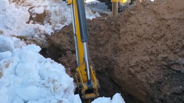 Cargador excavando tierra mojada en invierno — Vídeo de stock