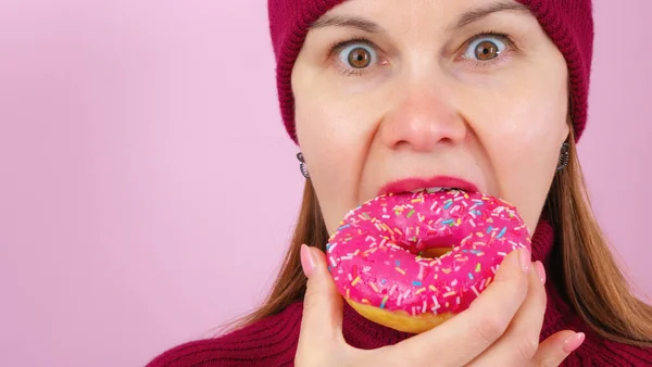 Yetişkin bir kadın lezzetli çörekleri ısırıyor.