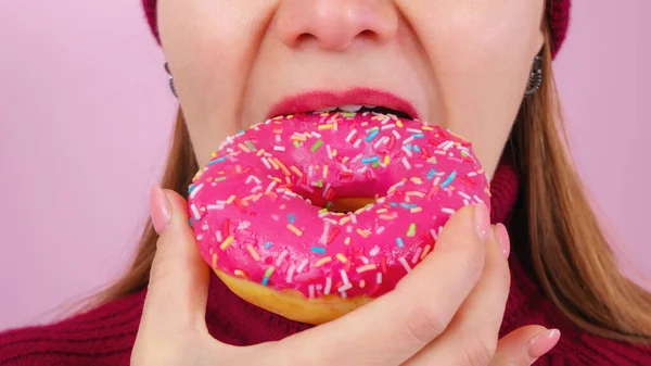Взрослая женщина кусает вкусный пончик Лицензионные Стоковые Изображения