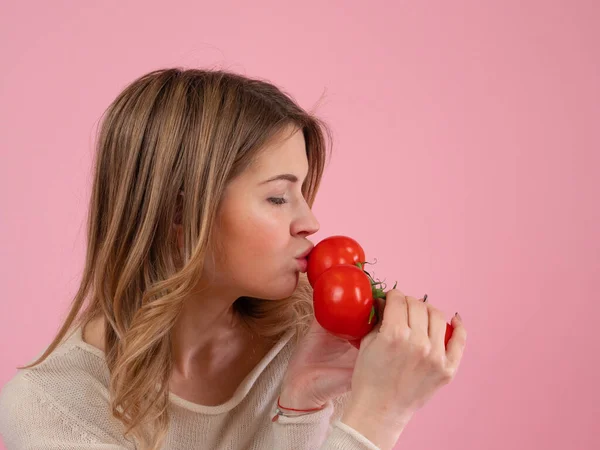 Modern kadın olgun domatesleri öpüyor.