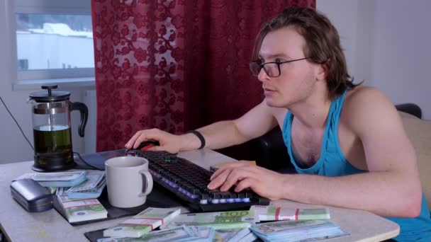 Обманутый мужчина использует настольный компьютер дома, чтобы заработать деньги в Интернете — стоковое видео