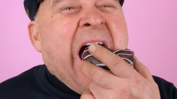 Дорослий чоловік їсть солодкий пончик — стокове відео