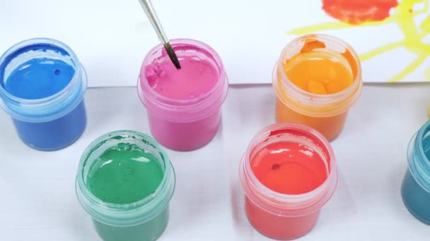 Jars with gouache paints on white table — Stock Video