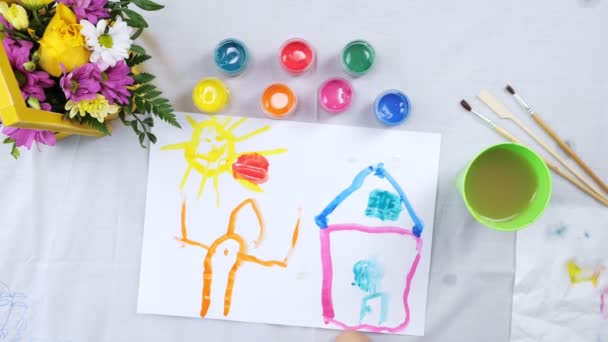 Маленька дівчинка малює з гуашем на білому папері — стокове відео
