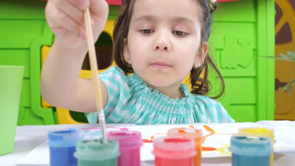 Dibujo de niña con gouache sobre papel blanco — Vídeo de stock