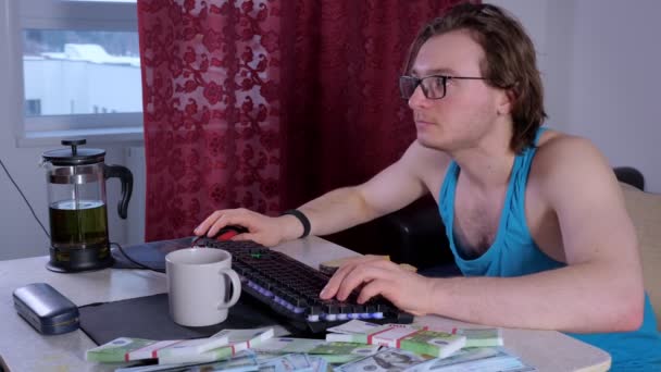 Обманутый мужчина использует настольный компьютер дома, чтобы заработать деньги в Интернете — стоковое видео