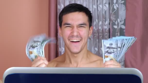 Joven utiliza un ordenador portátil para hacer dinero en Internet — Vídeo de stock