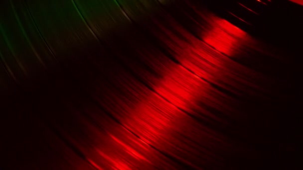 Fragment d'un disque vinyle rotatif dans les rayons rouges d'une discothèque — Video