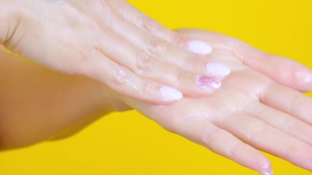 Une jeune femme met de la crème blanche sur ses mains — Video