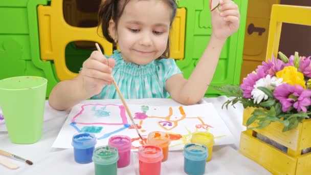 Kleines Mädchen zeichnet mit Gouache auf weißem Papier — Stockvideo