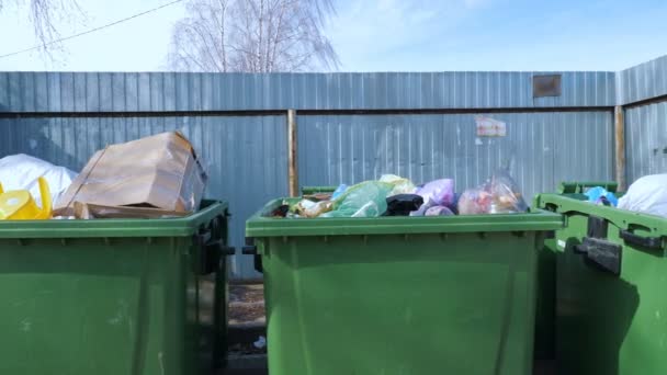 Waste bins near metal fence — Stock Video
