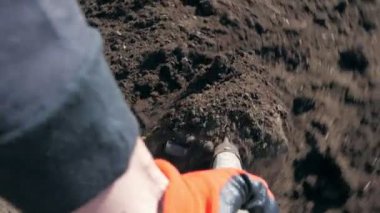 Bir çiftçi bahçesinde kürekle toprağı kazar.