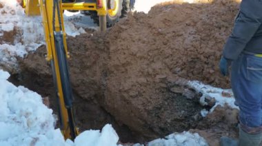 Loader digging wet ground in winter