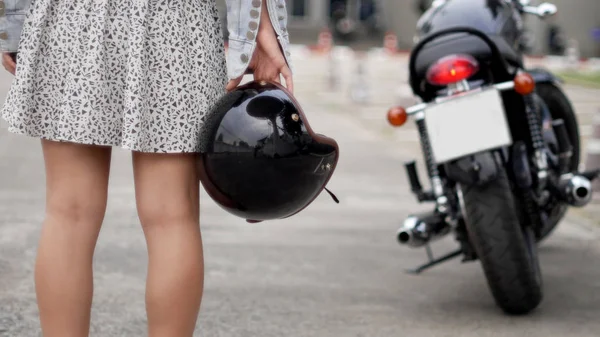 Kask tutan güzel kız motosiklet sürmeye hazırlanıyor.