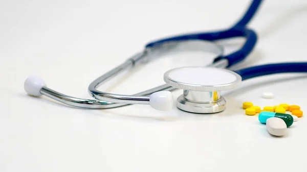 İlaçlar ve beyaz arka planda Doktor 'un kulaklıkları. Sağlık hizmeti kavramı. Ve yaşlılıkta tıbbi bakım..