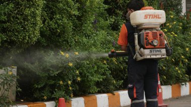 Bangkok / Tayland-21 Mart 2020: Koruyucu maskeli dezenfektan işçisi ve giysi bakteri veya virüs püskürtüyor. Covid-19 salgınlarını önlemek için ofis bölgesinde koronavirüs temizliği..