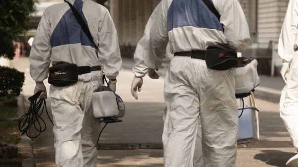 Bangkok / Tayland-21 Mart 2020: Koruyucu maskeli dezenfektan işçisi ve giysi bakteri veya virüs püskürtüyor. Covid-19 salgınlarını önlemek için ofis bölgesinde koronavirüs temizliği..
