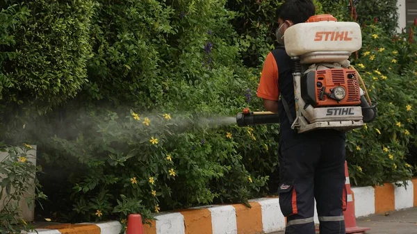 Bangkok / Tayland-21 Mart 2020: Koruyucu maskeli dezenfektan işçisi ve giysi bakteri veya virüs püskürtüyor. Covid-19 salgınlarını önlemek için ofis bölgesinde koronavirüs temizliği..