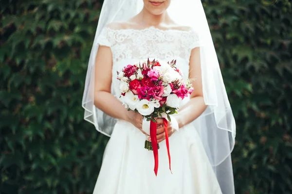 Casamento. A noiva em um vestido que está em um jardim verde e álcool — Fotografia de Stock