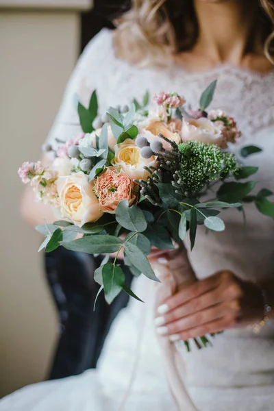 Mariée en robe assis sur la chaise et tenant bouquet de mariage de f — Photo