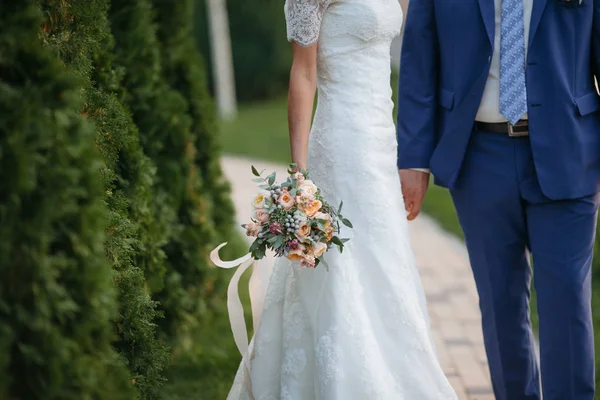 Matrimonio. Lo sposo in un costume e la sposa in un vestito bianco stan — Foto Stock