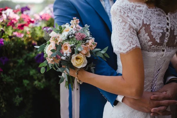 Bruiloft. De bruidegom in een pak en de bruid in een witte jurk stan — Stockfoto