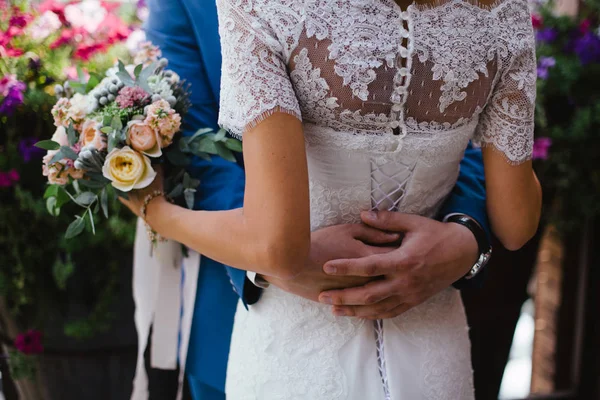 Bruiloft. De bruidegom in een pak en de bruid in een witte jurk stan — Stockfoto